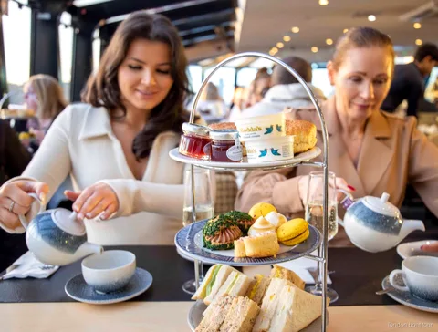 Afternoon tea stand with sandwiches and scones served on a Thames river cruise